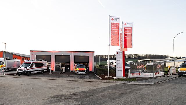 DRK Kursstandort Lich – Erste-Hilfe-Ausbildung im modernen Schulungszentrum DRK-Gebäude in Lich mit Einsatzfahrzeugen und Fahnen des Deutschen Roten Kreuzes