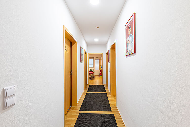 Heller Flur der DRK Therapiepraxis Alten-Buseck Flur mit Türen und Wandbildern in der DRK Therapiepraxis Alten-Buseck