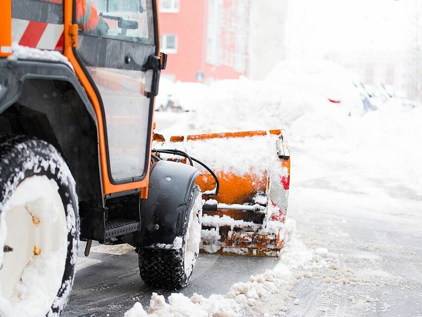 Winterdienst und Schneeräumung – DRK Hausmeisterservice Mittelhessen Schneeräumfahrzeug entfernt Schnee von Gehweg und Straße