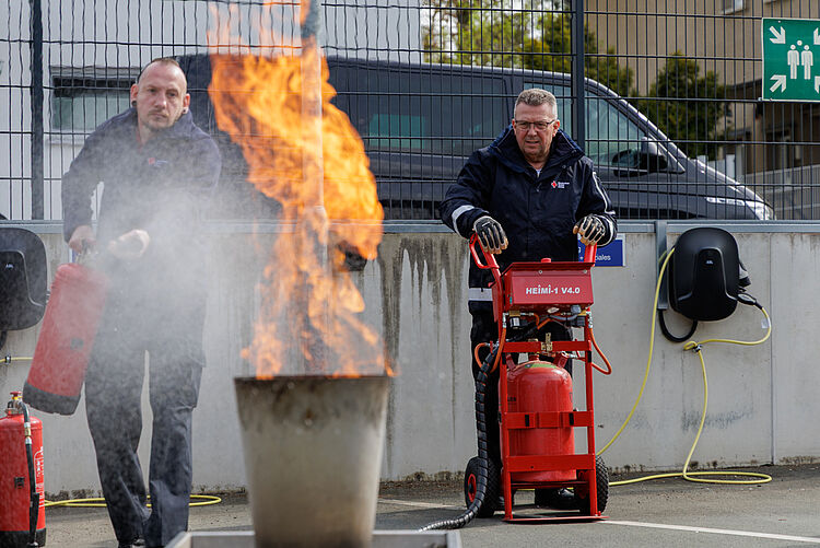 Feuerlöschtraining Brandschutzhelfer DRK Mittelhessen Übung Teilnehmer löschen kontrolliertes Feuer mit Löschgerät beim Brandschutzhelfer Lehrgang