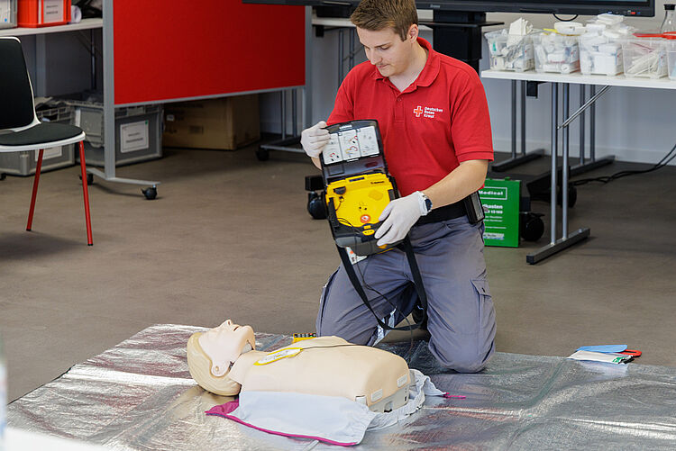 DRK Erste-Hilfe-Kurs: Einsatz eines Defibrillators DRK-Ausbilder demonstriert die Nutzung eines Defibrillators an einer Übungspuppe