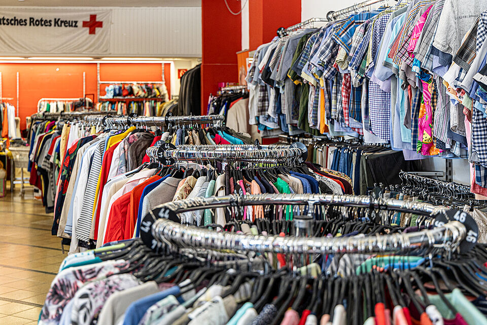 Große Auswahl an Kleidung im DRK Kleiderladen Kleiderstangen voller Second-Hand-Kleidung im DRK Kleiderladen