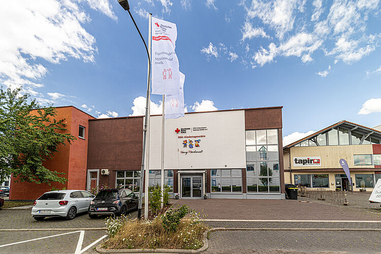 Gebäude der DRK-Kita „Henrys Märchenwelt“ in Heuchelheim Außenansicht der DRK-Kindertagesstätte „Henrys Märchenwelt“ mit Fahnen und Eingang