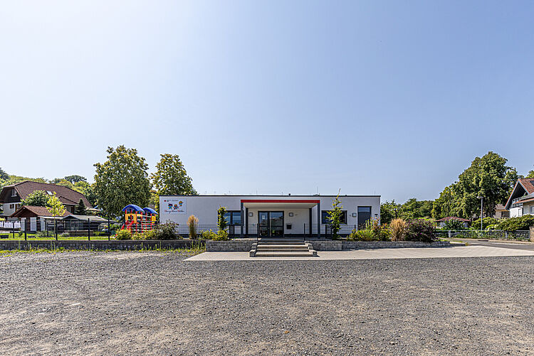 DRK-Kita Henrys kleine Helden in Rabenau-Geilshausen – moderne Kindertagesstätte mit Herz Außenansicht der DRK-Kita Henrys kleine Helden in Rabenau-Geilshausen mit Spielplatz und GartenDie moderne DRK-Kita „Henrys kleine Helden“ in Rabenau-Geilshausen bietet Kindern Raum zum Entdecken, Spielen und Lernen. Das Gebäude fügt sich harmonisch in die Umgebung ein und lädt Familien herzlich ein.