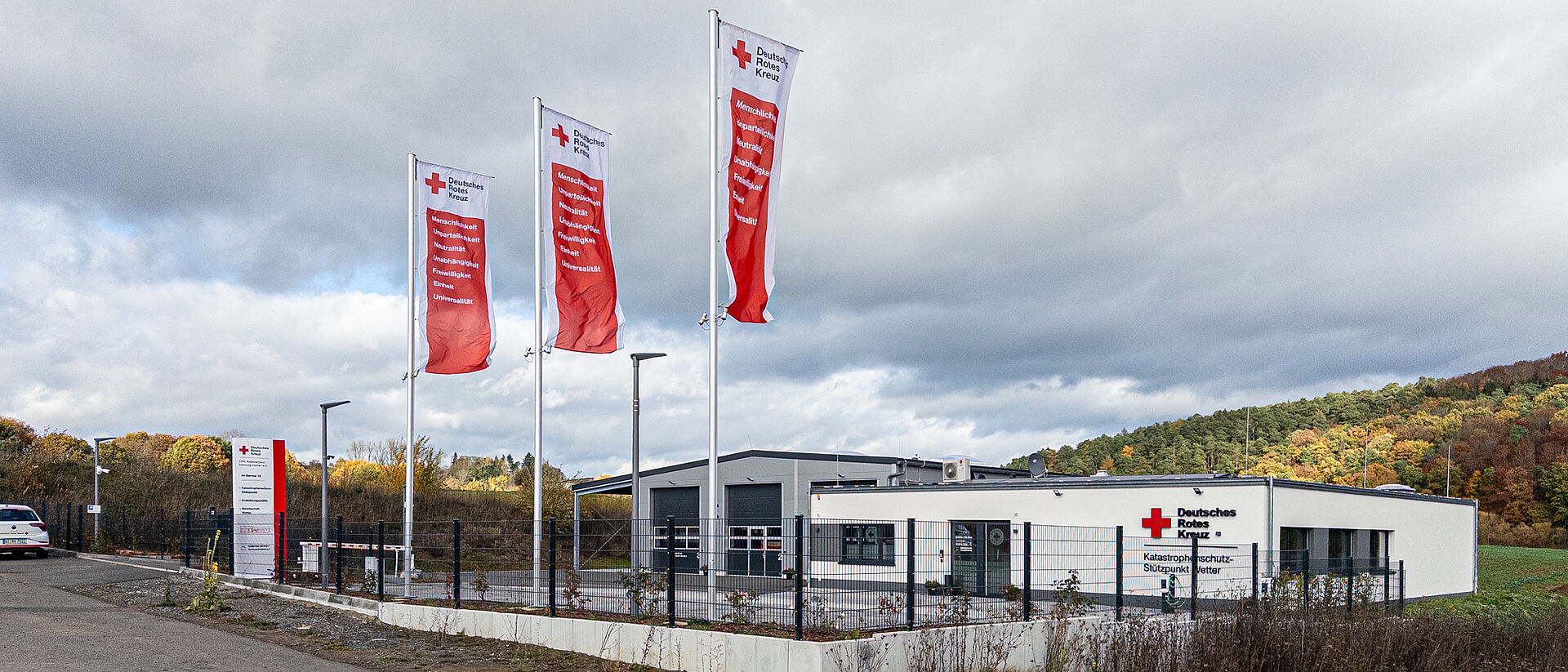 DRK Kursstandort Wetter – Schulungszentrum für Erste Hilfe und Katastrophenschutz DRK-Stützpunkt Wetter bei Nacht mit rot beleuchtetem Gebäude und DRK-Logo