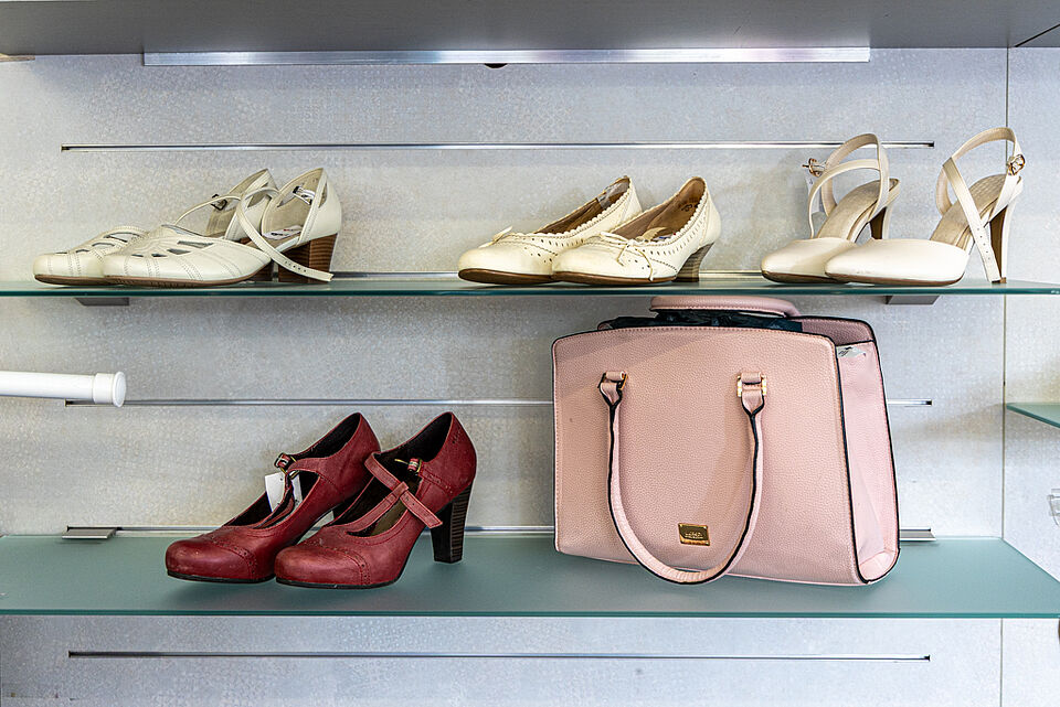 Second-Hand-Schuhe und Tasche im DRK Kleiderladen Schuhe und rosa Tasche im DRK Kleiderladen
