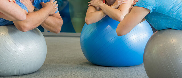 Wirbelsäulengymnastik und Training mit Gymnastikball beim DRK in Mittelhessen Teilnehmende beim Wirbelsäulentraining auf Gymnastikbällen in der DRK-Therapiepraxis