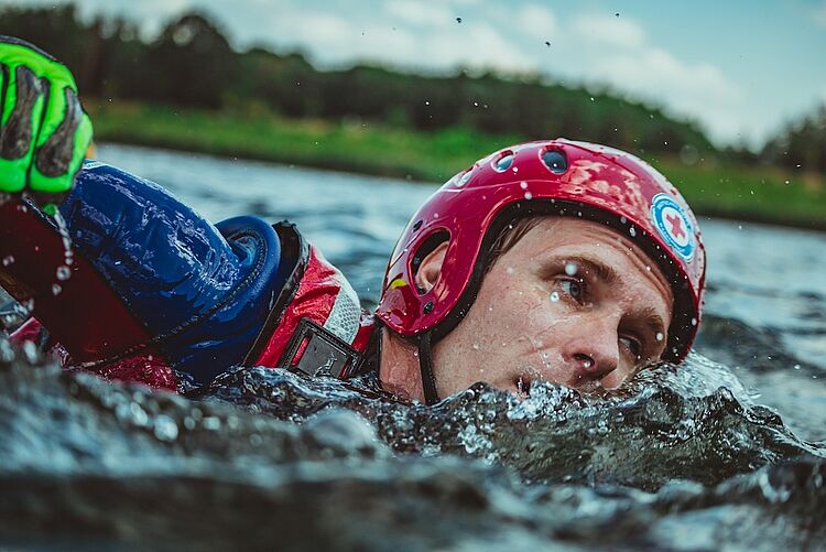 Wasserrettung Gießen – DRK Rettungsschwimmer Kurs in Mittelhessen DRK Rettungsschwimmer mit Helm und Neoprenanzug bei einer Wasserrettungsübung im Freiwasser