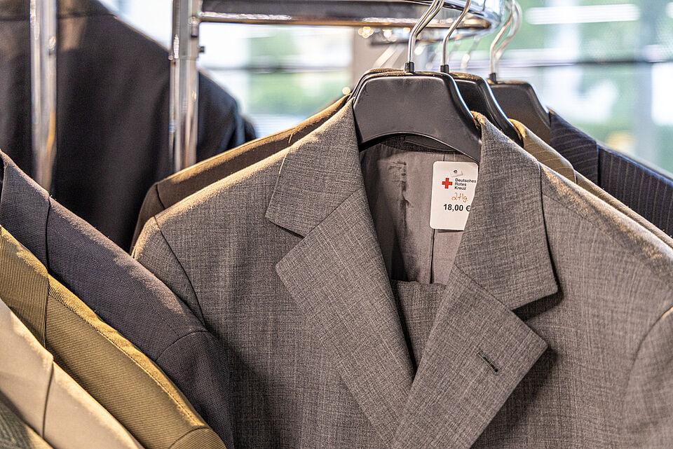 DRK Kleiderladen Stadtallendorf – Herrenanzüge Second-Hand Grauer Anzug auf Kleiderbügel im DRK Kleiderladen Stadtallendorf