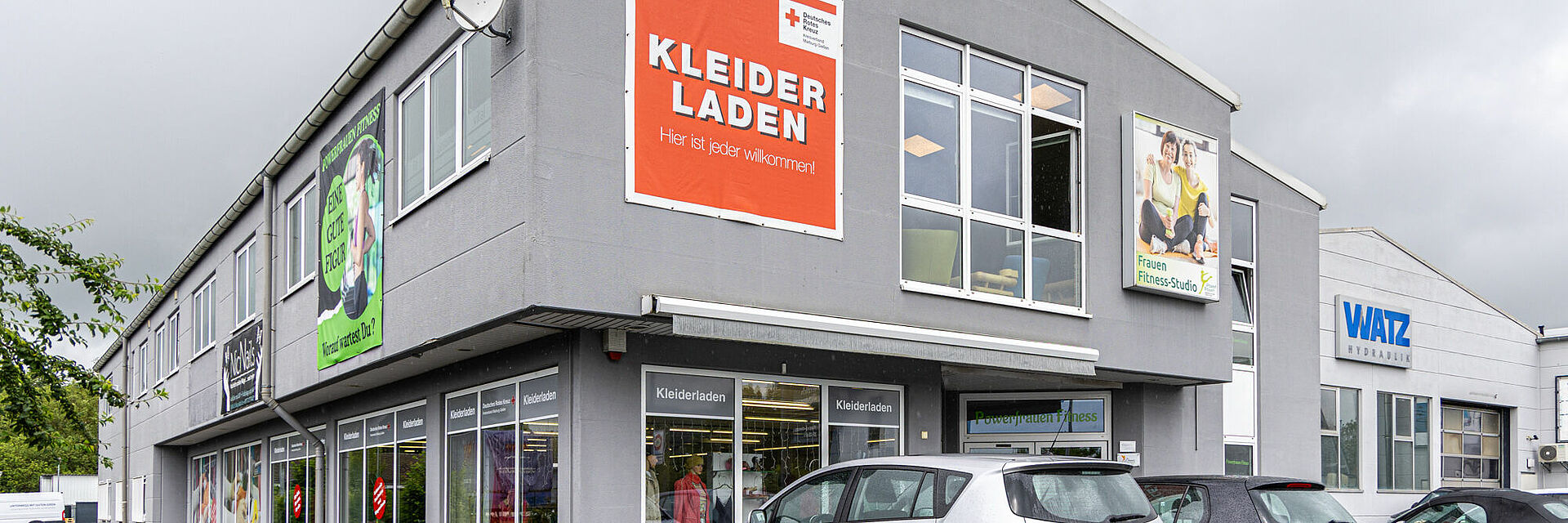 DRK Kleiderladen Lollar – Günstig einkaufen & Gutes tun Außenansicht des DRK Kleiderladens in Lollar mit großem Willkommensschild