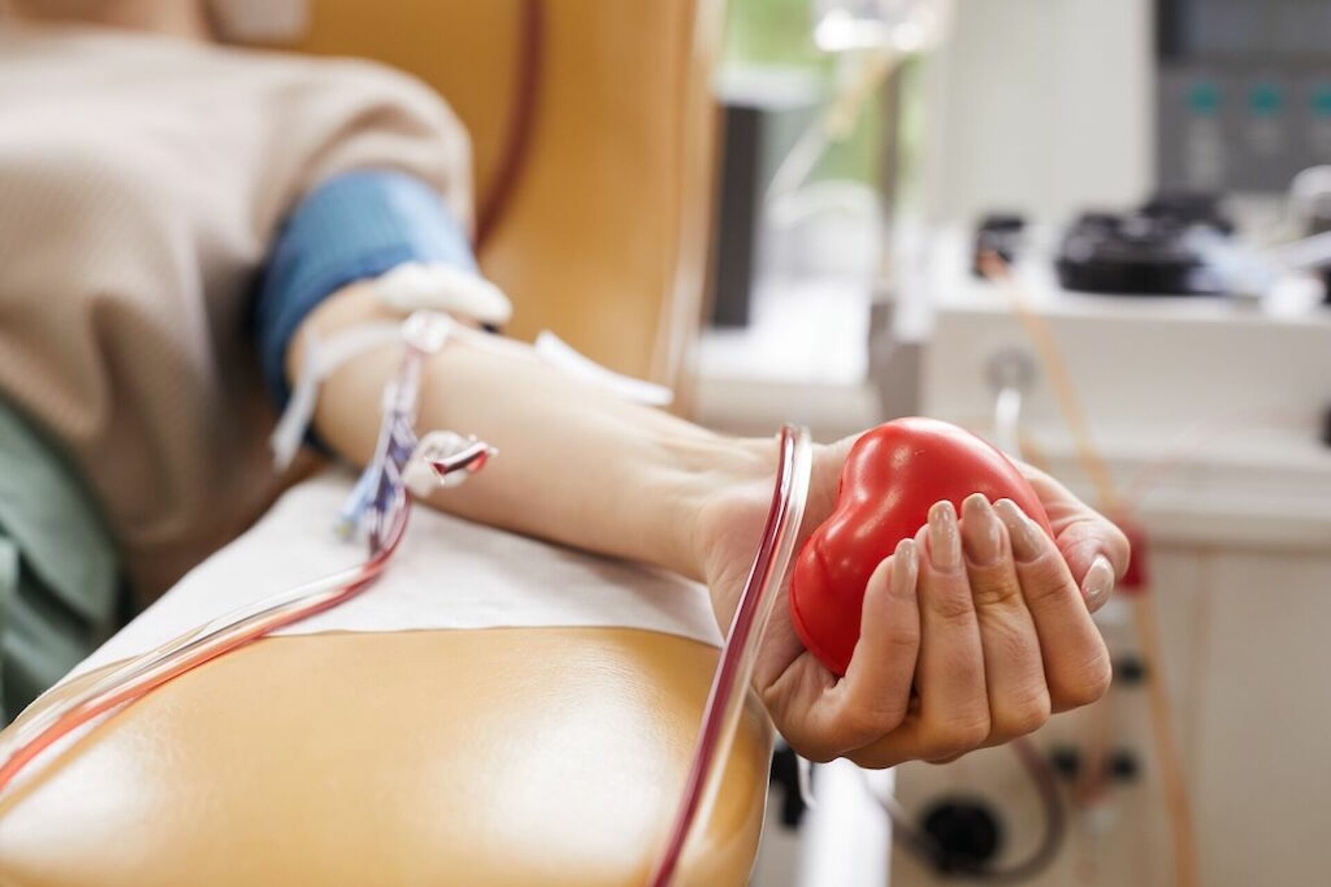 Blut spenden – Leben retten mit dem DRK Mittelhessen Arm mit Infusionsnadel bei der Blutspende, Hand hält rotes Herz