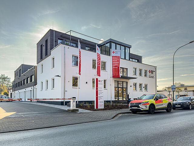 DRK Kreisverband Marburg-Gießen – Verwaltungs- und Kursstandort in der Eichgärtenallee Gebäude des DRK Kreisverbands Marburg-Gießen in der Eichgärtenallee mit DRK-Fahnen und geparkten Einsatzfahrzeugen