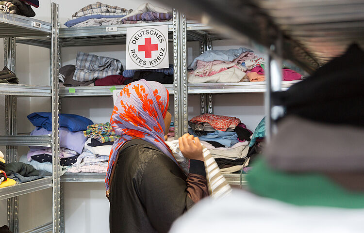 DRK Kleiderkammer Lich – Hilfe, Würde und Nachhaltigkeit Frau sucht Kleidung in der DRK Kleiderkammer Lich vor Regalen mit gespendeten Textilien