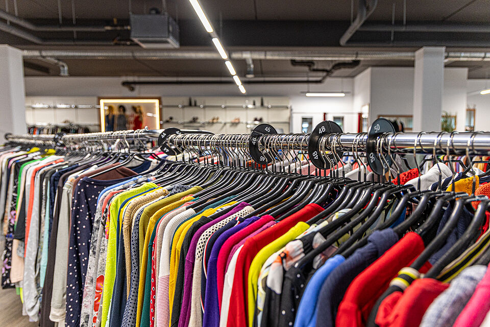 DRK Kleiderladen Stadtallendorf – Damenmode Second-Hand Kleiderständer mit bunter Damenmode im DRK Kleiderladen Stadtallendorf