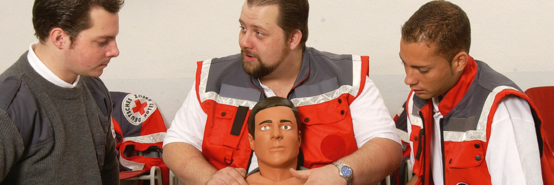 DRK Erste-Hilfe-Fortbildung für Einsatzkräfte Drei DRK-Helfer üben Wiederbelebung an einer Übungspuppe
