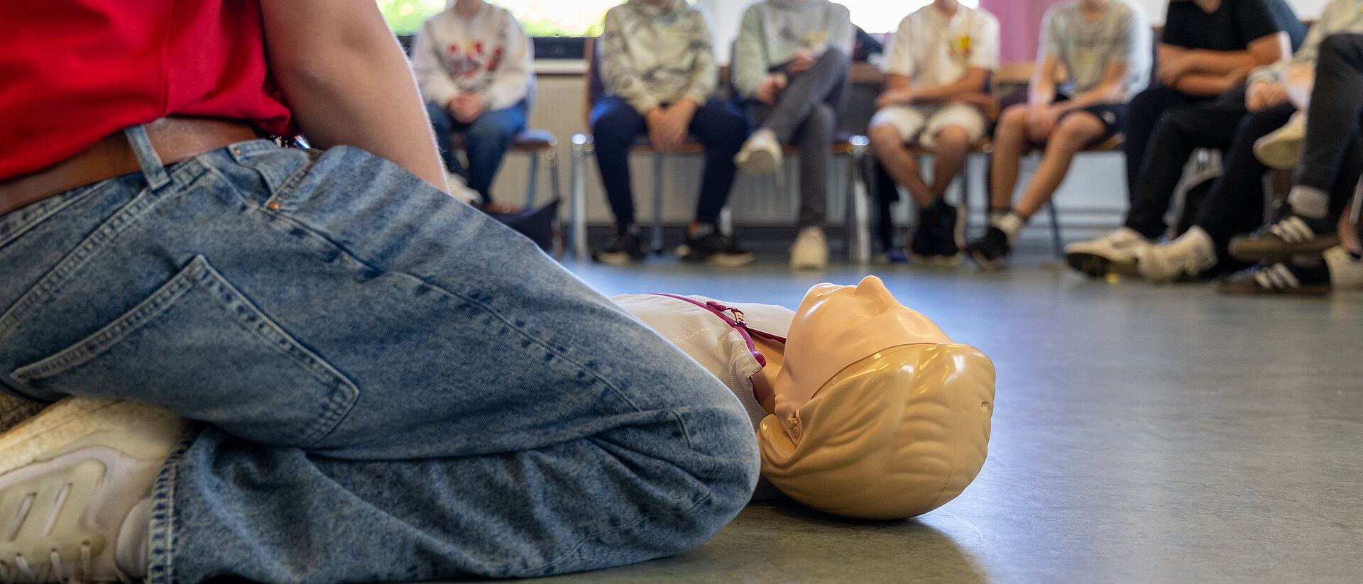 Erste-Hilfe-Training für Jugendliche – DRK Mittelhessen stärkt Schularbeit Schüler lernen Wiederbelebung mit Übungspuppe beim DRK-Training