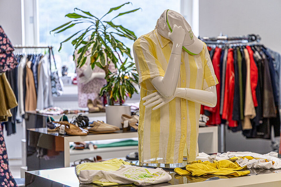 DRK Kleiderladen Marburg – Schaufensterpuppe mit Sommermode Schaufensterpuppe mit gelbem Hemd im DRK Kleiderladen Marburg