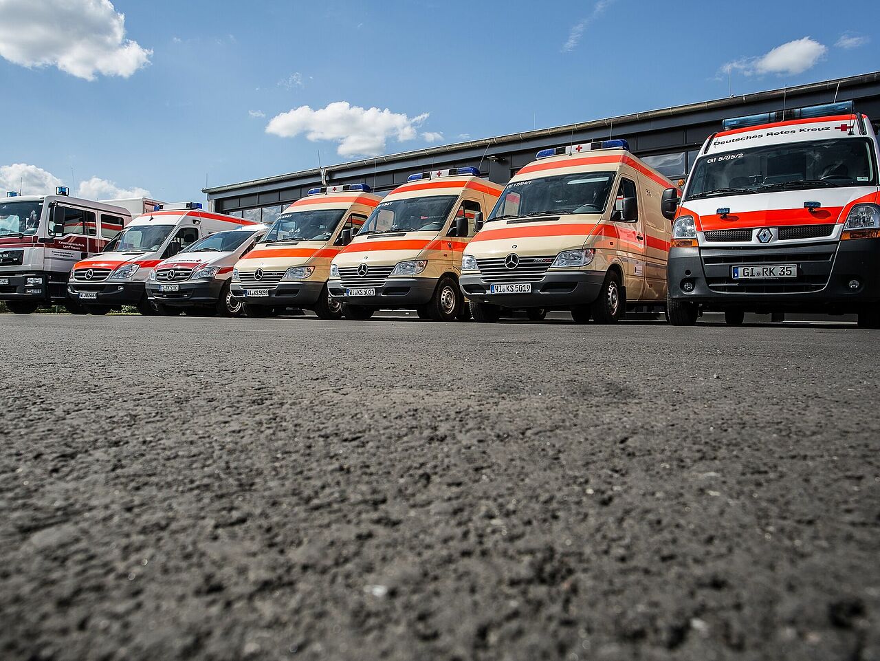 DRK Mittelhessen – Sanitätszug mit Rettungs- und Einsatzfahrzeugen Sanitätsfahrzeuge und Einsatzwagen des DRK Mittelhessen in Reihung vor der Halle