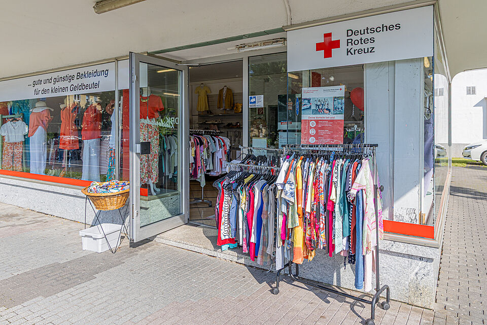 DRK Kleiderladen Gießen – Kleiderständer vor dem Eingang Kleiderständer mit Mode vor dem DRK Kleiderladen