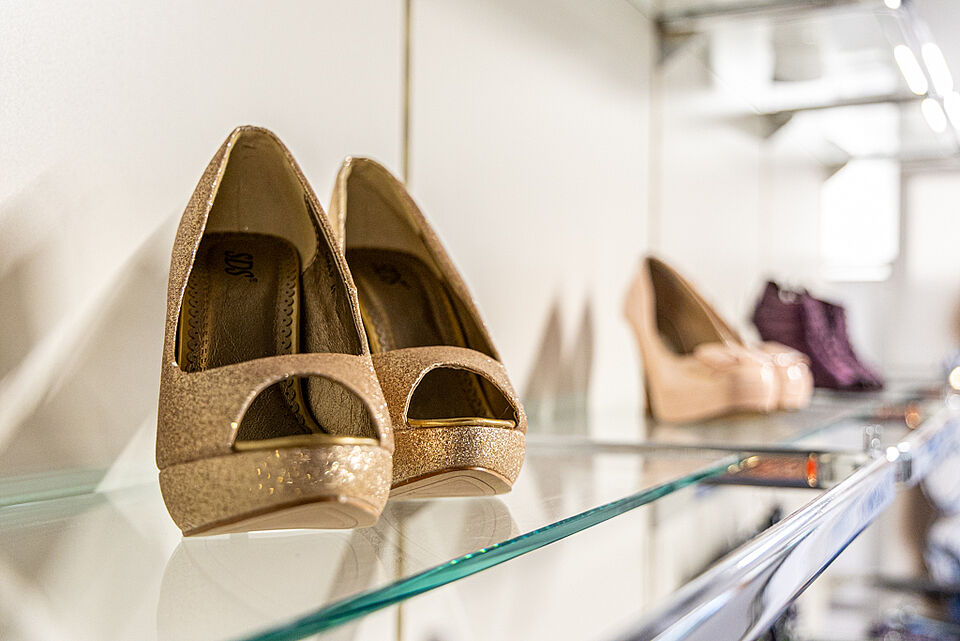 DRK Kleiderladen Stadtallendorf – Schuhe für Damen Second-Hand Goldfarbene Pumps im Regal im DRK Kleiderladen Stadtallendorf