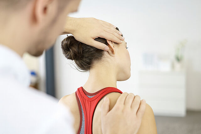 Physiotherapie für Nacken und Schultern – Behandlung beim DRK Mittelhessen Physiotherapeut behandelt Nacken einer Patientin
