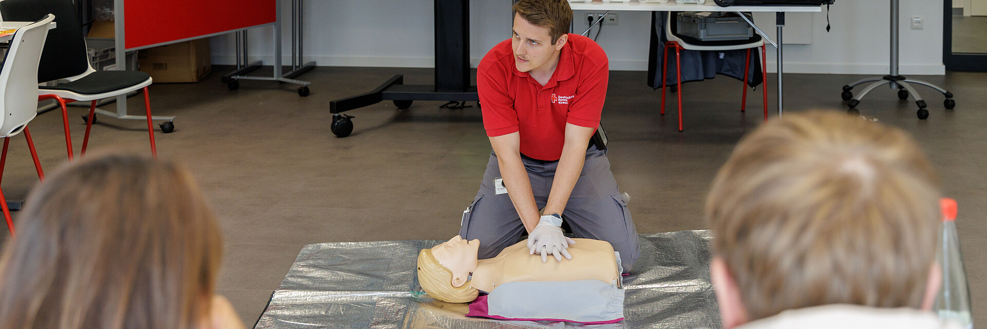 Erste-Hilfe-Kurs beim DRK Mittelhessen – Lebensrettende Sofortmaßnahmen lernen Ausbilder des DRK Mittelhessen zeigt an einer Übungspuppe die Herz-Lungen-Wiederbelebung während eines Erste-Hilfe-Kurses