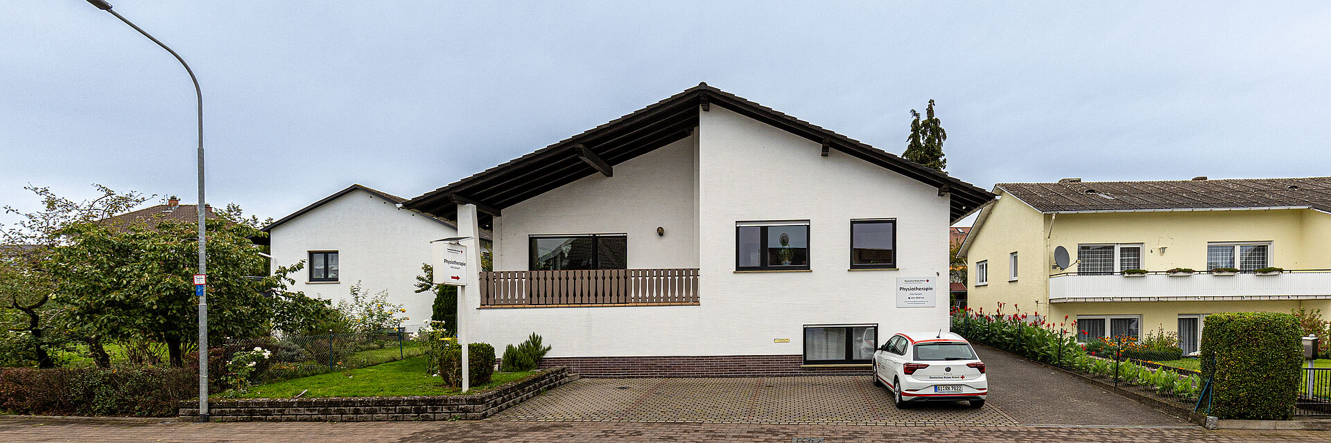 Außenansicht der DRK Therapiepraxis Alten-Buseck Außenansicht des Gebäudes der DRK Therapiepraxis Alten-Buseck mit DRK-Fahrzeug