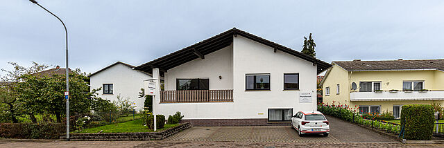 Außenansicht der DRK Therapiepraxis Alten-Buseck Außenansicht des Gebäudes der DRK Therapiepraxis Alten-Buseck mit DRK-Fahrzeug