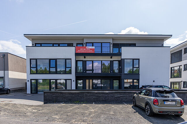 DRK Logopädiepraxis Marburg-Cappel Modernes Gebäude der neuen DRK Logopädiepraxis in Marburg-Cappel mit Banner „Neu ab 1. Juli“