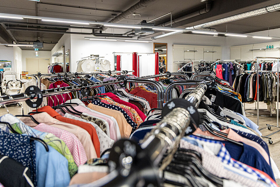 DRK Kleiderladen Stadtallendorf – Modevielfalt im Laden Bunte Kleidungsstücke auf Ständern im DRK Kleiderladen Stadtallendorf