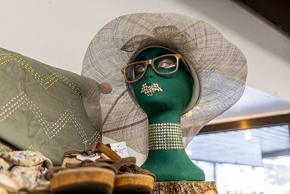 Kreatives Schaufenster im DRK Kleiderladen Gießen Schaufensterpuppe mit Hut und Brille im DRK Kleiderladen