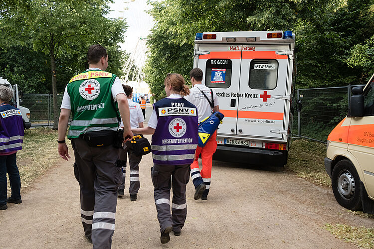 DRK Mittelhessen – PSNV-Team im Einsatz nach belastenden Ereignissen Einsatzkräfte der Psychosozialen Notfallversorgung (PSNV) des DRK begleiten ein Rettungsteam vor einem Einsatzfahrzeug