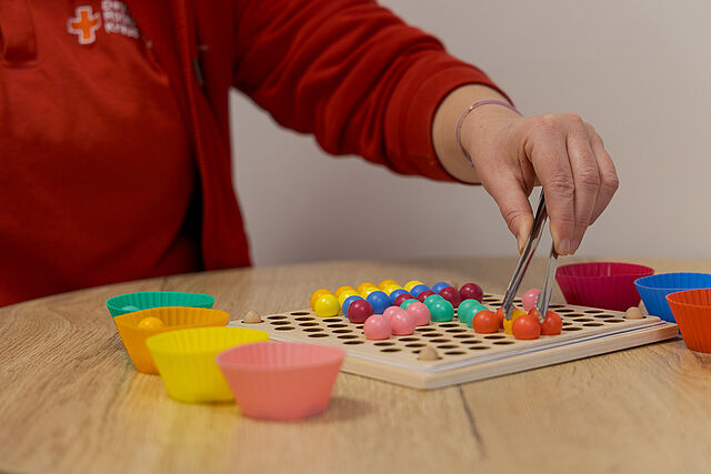 Ergotherapie Feinmotorik Übungen Ergotherapeutische Feinmotorikübung mit bunten Kugeln und Pinzette