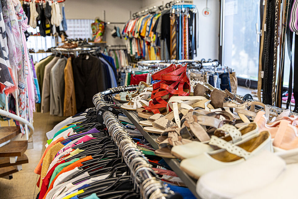Secondhand-Mode im DRK Kleiderladen Gießen Kleiderstangen und Schuhe im Verkaufsraum des DRK Kleiderladens