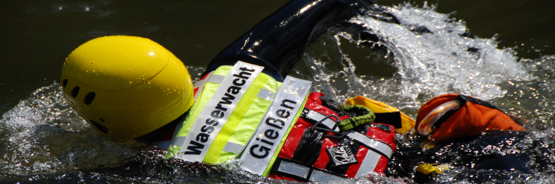 DRK Mittelhessen – Wasserwacht Gießen im Rettungseinsatz Mitglied der Wasserwacht Gießen mit Helm und Rettungsweste schwimmt im Einsatz